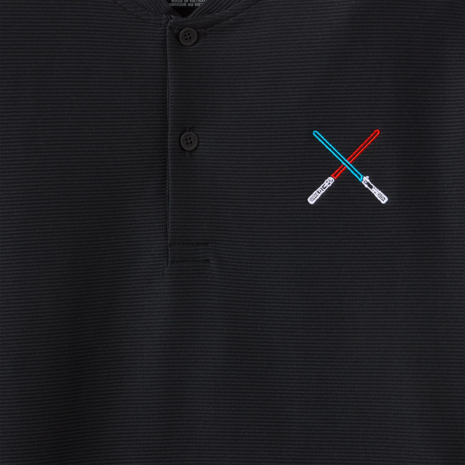 Close view of crossed Lightsabers embroidered on the black Nike polo