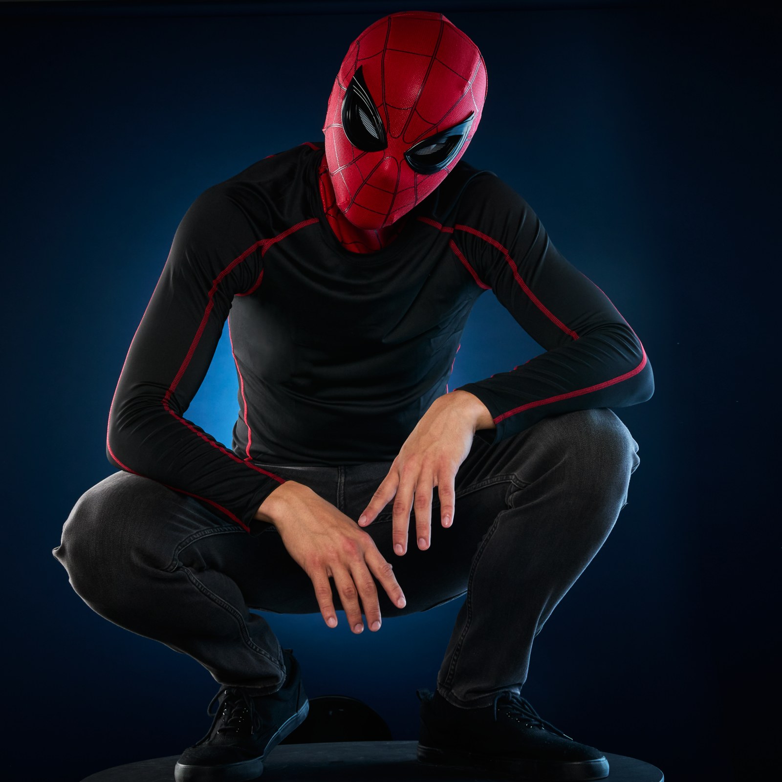 Person crouching while wearing the Spider-Man expressive mask