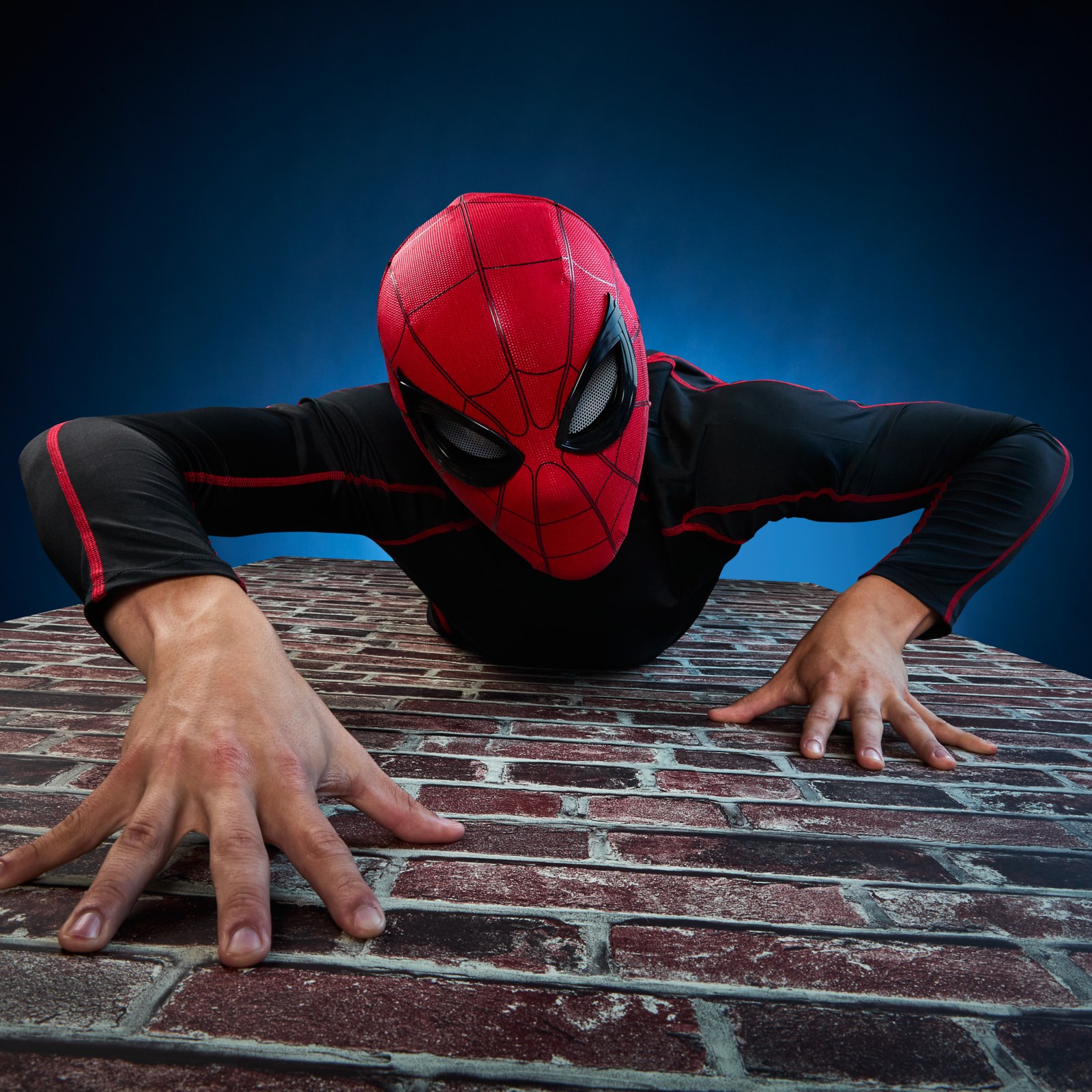 Person climbing a brick wall while wearing the Spider-Man mask