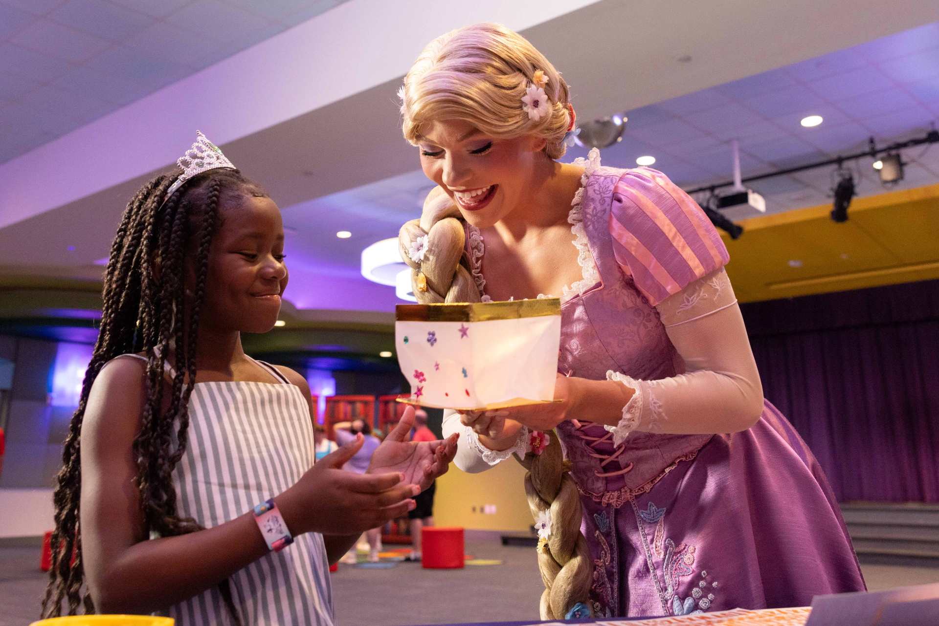 Rapunzel helps children decorate paper lanterns during World Princess Week