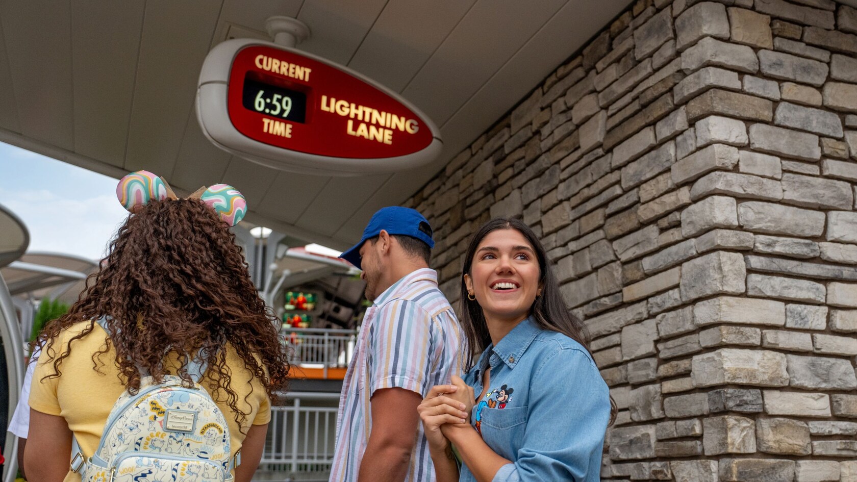Family entering a Disneyland Lightning Lane entrance beneath a Lightning Lane sign