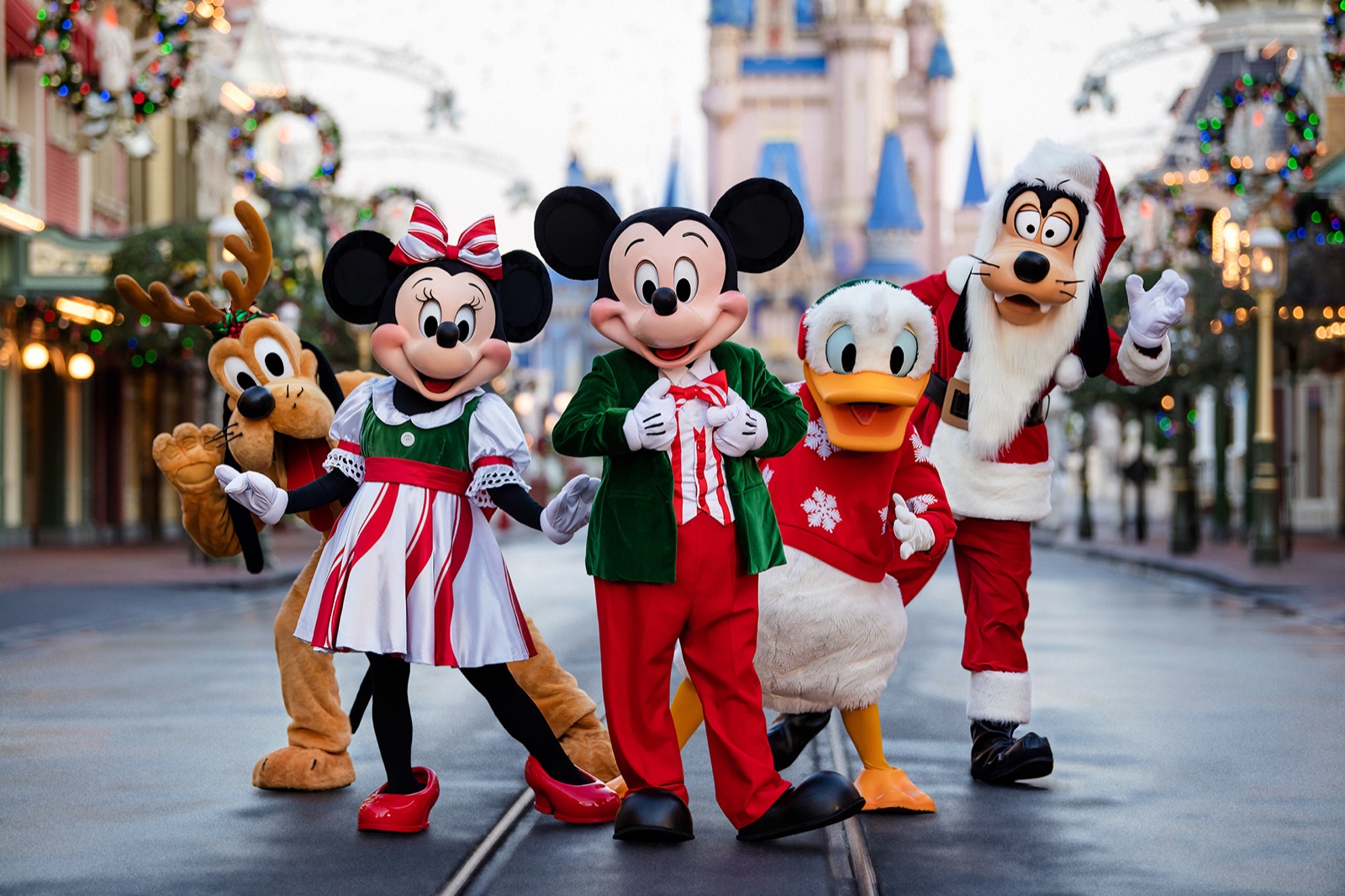Mickey, Minnie, Donald, Goofy, and Pluto in holiday clothes on Main Street at Magic Kingdom