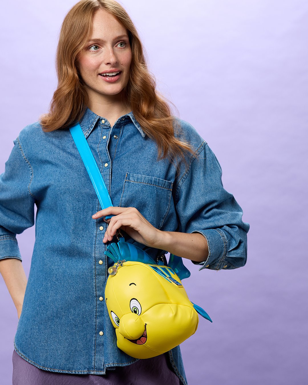 A model wears the Flounder Loungefly crossbody bag from Disney Store
