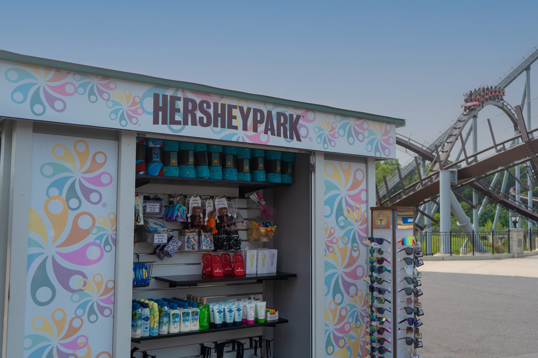 Hersheypark-branded Supply Co. mini-store with merchandise and a roller coaster behind it