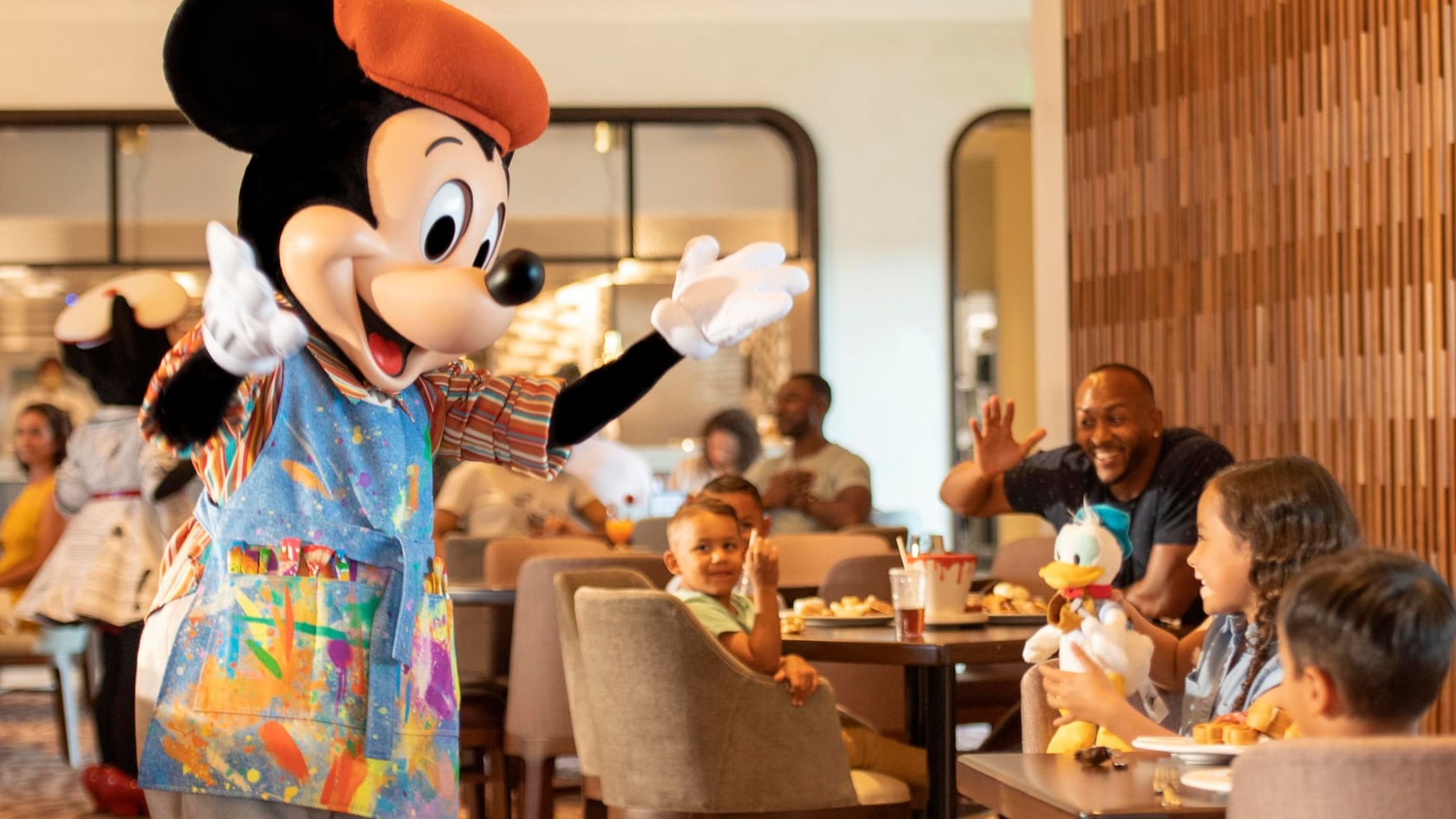 Mickey Mouse greets a family at Topolino's Terrace