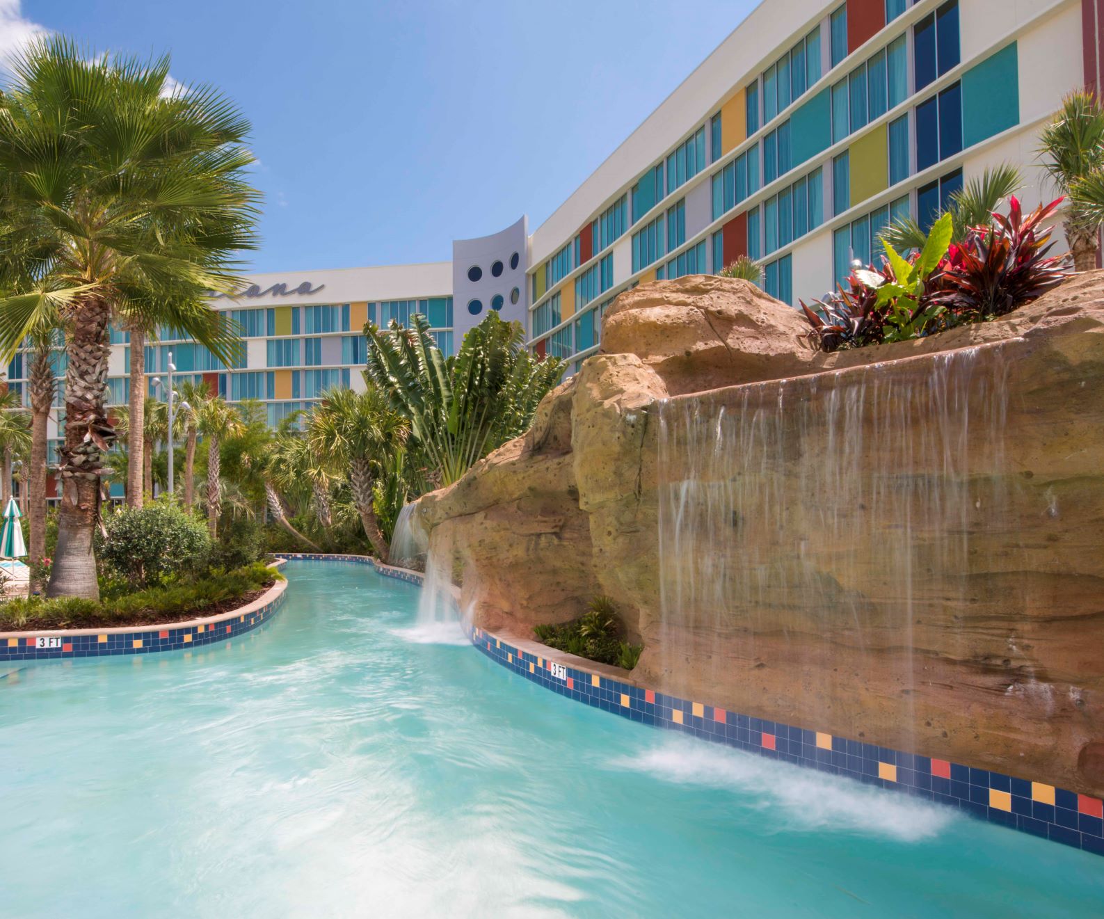 Cabana Bay Beach Resort lazy river winding past a colorful retro hotel building
