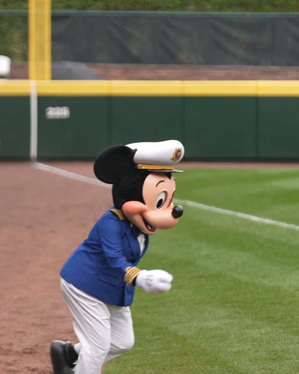 Captain Mickey Mouse in a Disney Cruise Line captain's hat runs across a baseball field