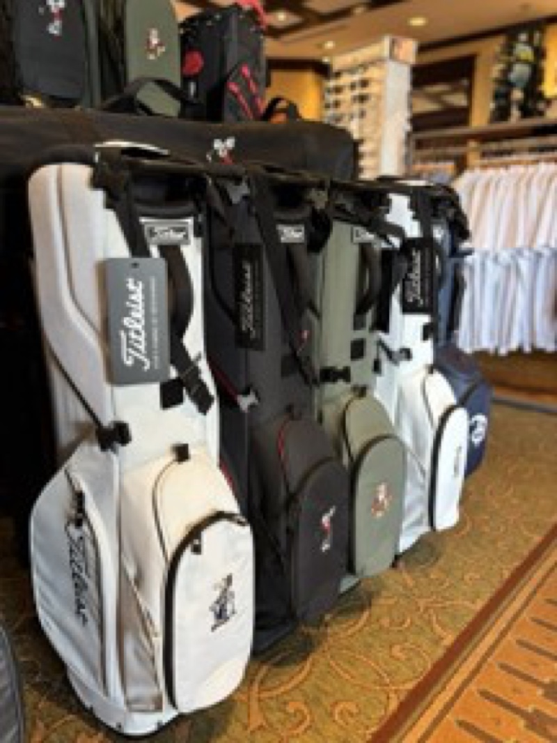 Several character-inspired Titleist golf bags displayed at a Walt Disney World Golf shop