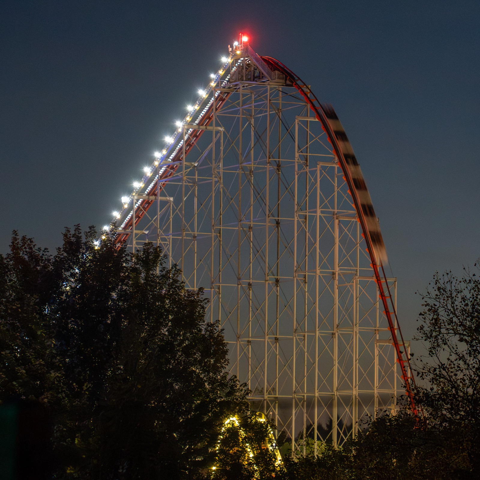 An illuminated Dorney Park roller coaster rises into the night sky