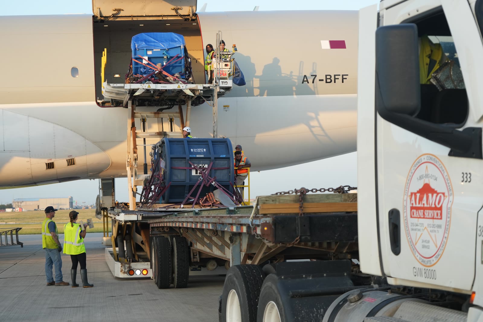Beluga transport containers are loaded onto an aircraft and truck at an airport