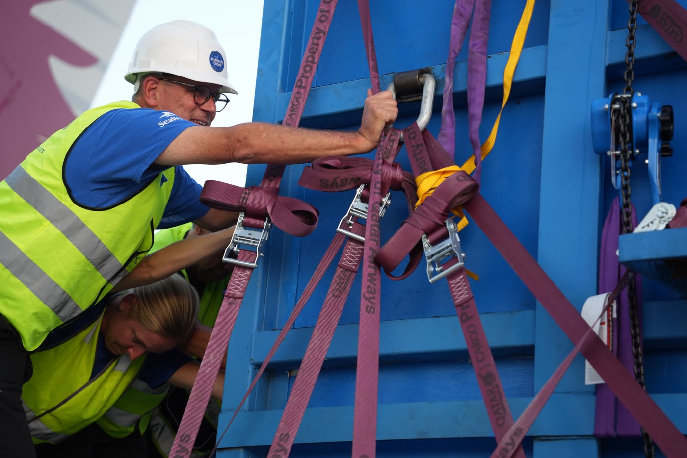 SeaWorld animal-care staff work beside a blue beluga transport container