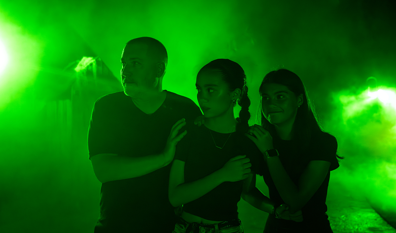 Guests in a green-lit Howl-O-Scream setting at SeaWorld Orlando