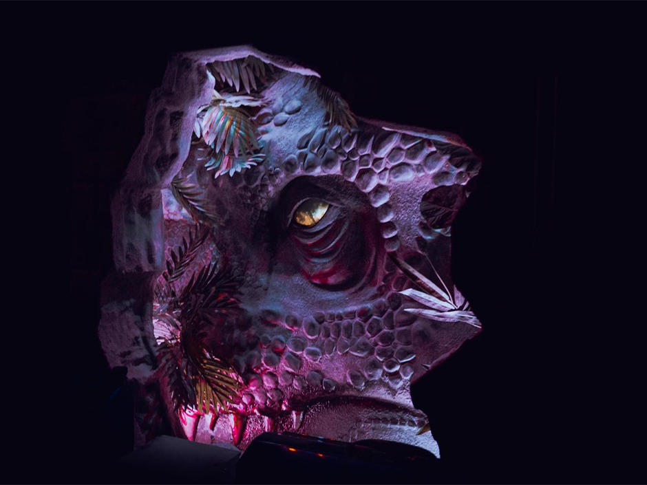 A dinosaur eye pokes through the metal inside Jurassic World: Escape at Universal CityWalk