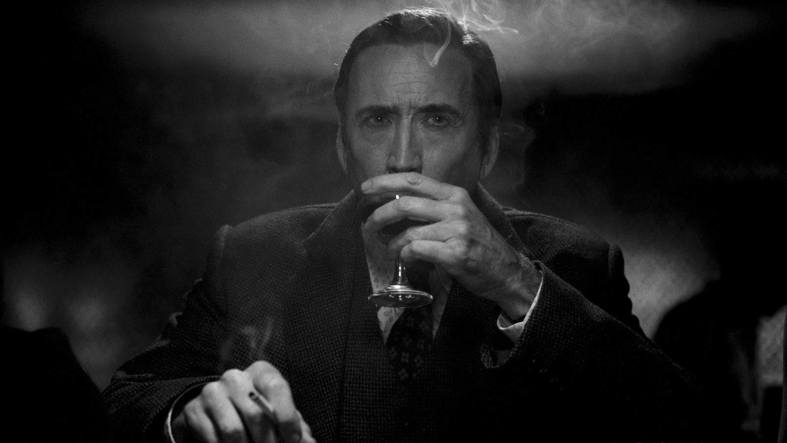 Nicolas Cage as Ben Reilly holding a glass in a dark room