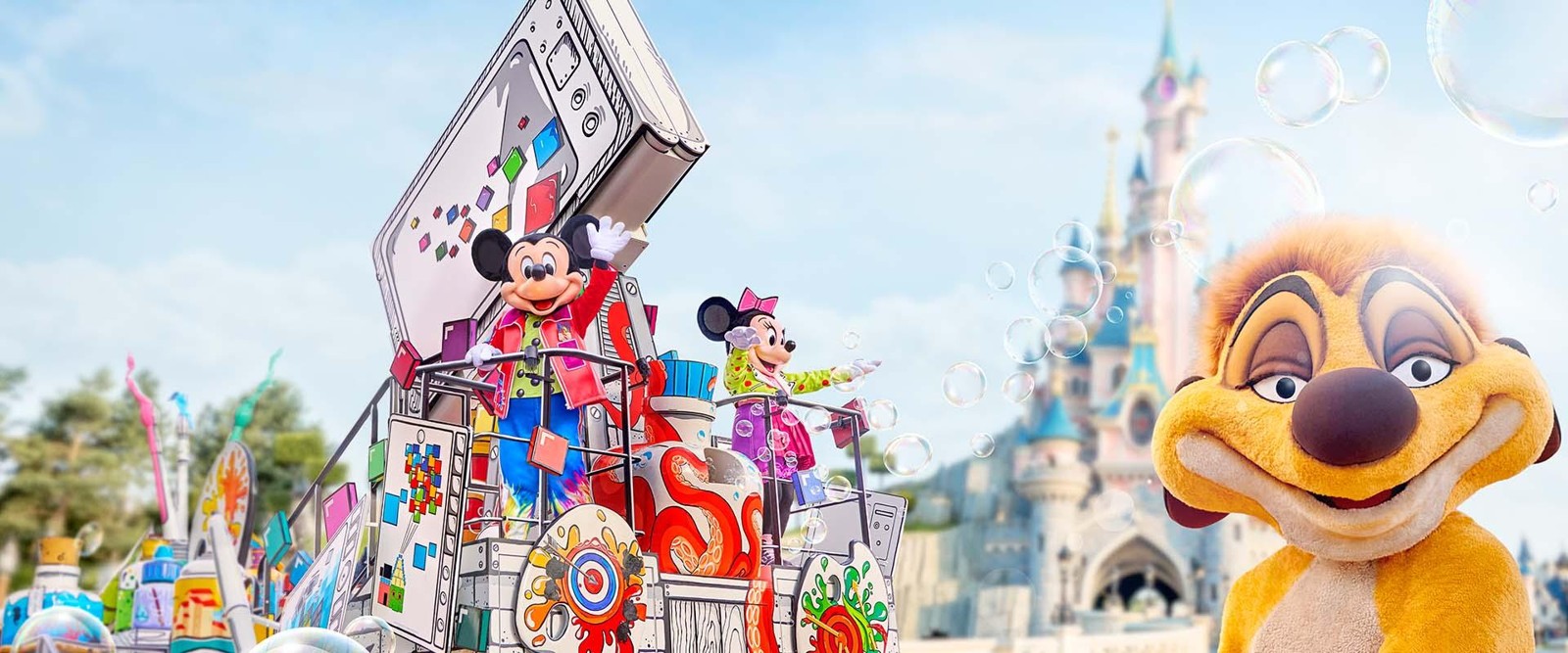 Timon beside Mickey and Minnie on a colorful A Million Splashes of Colour float near Sleeping Beauty Castle