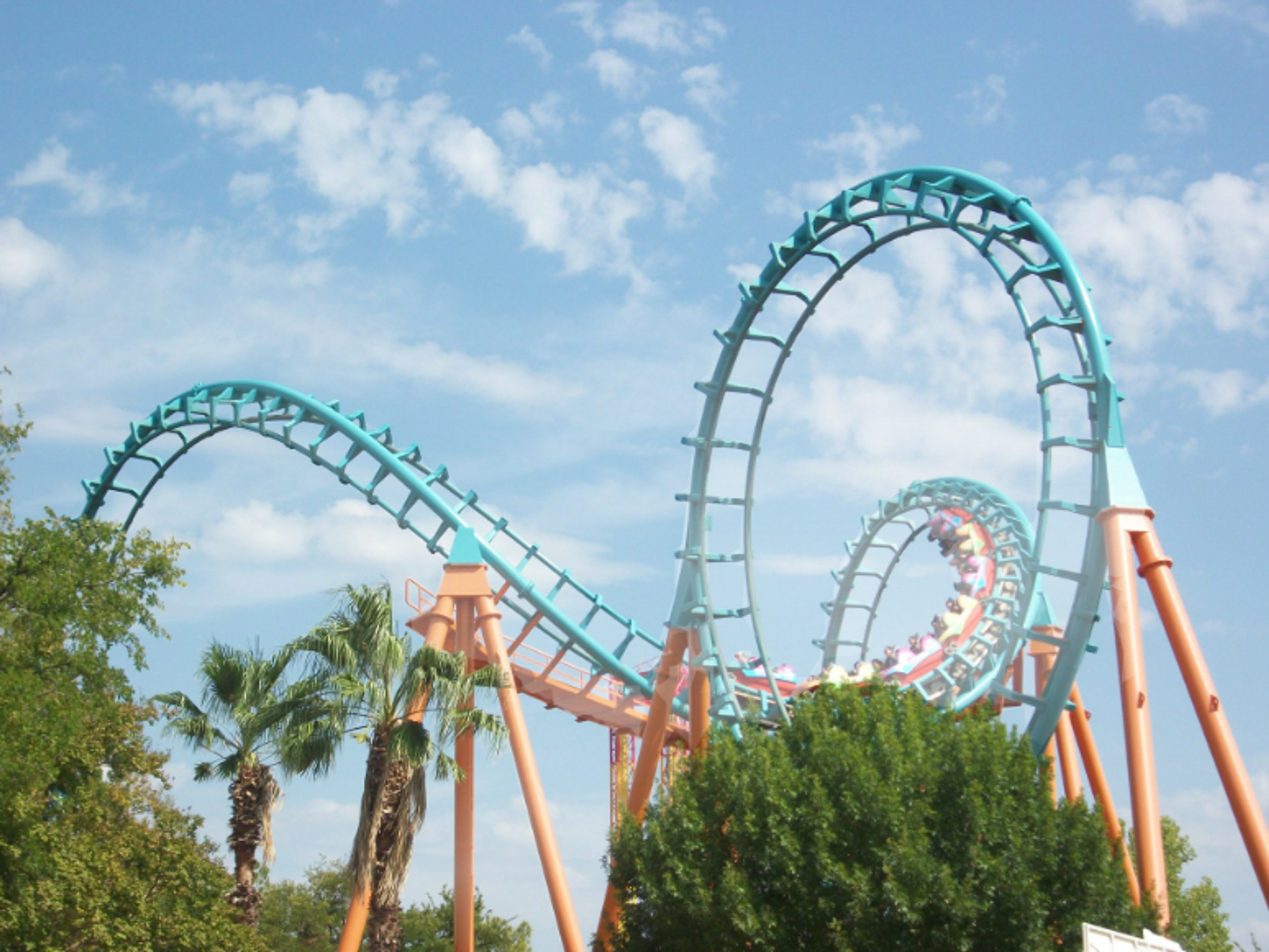 Roller coaster track at a Six Flags park beneath a blue sky