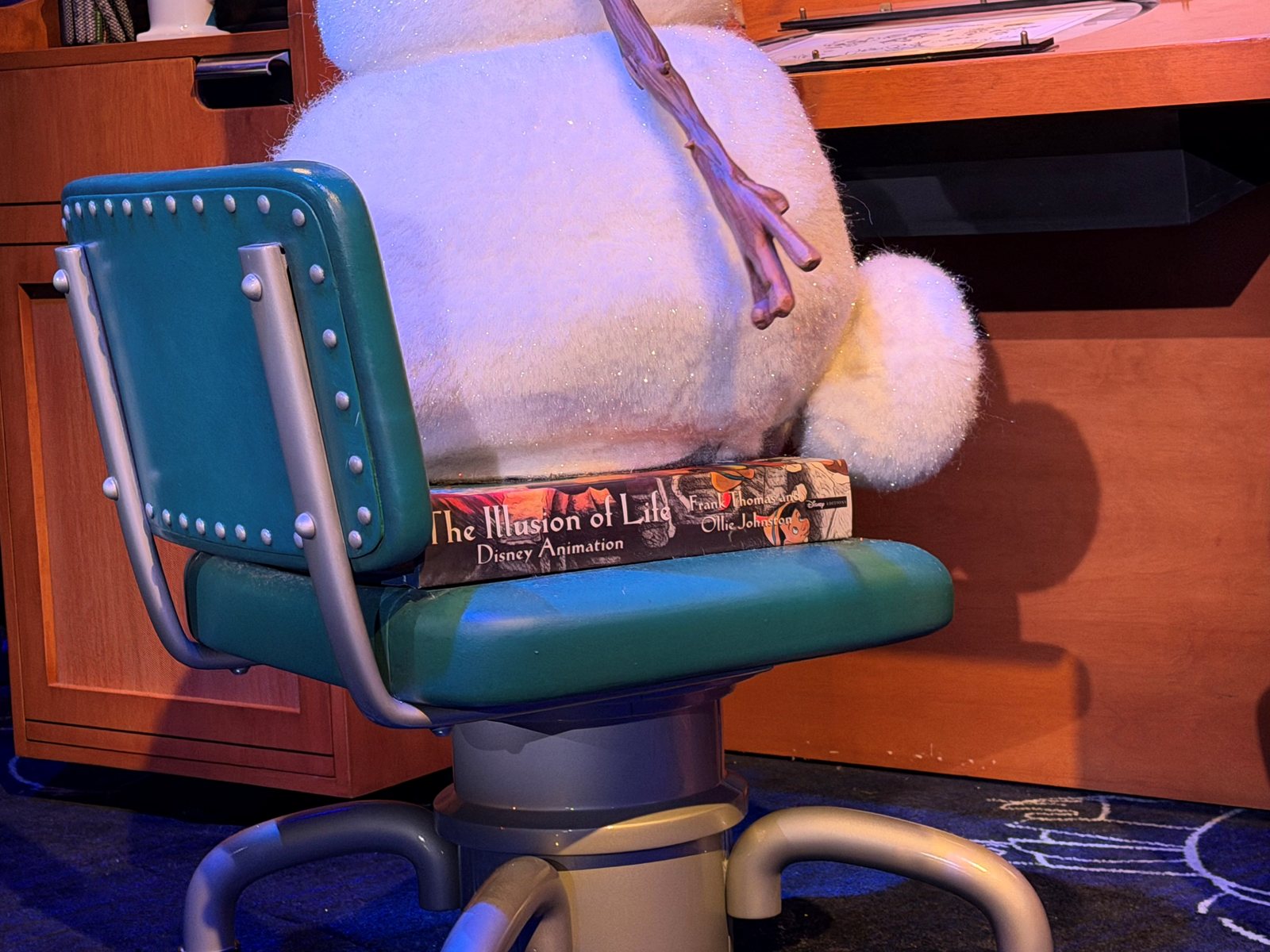 Olaf seated at an animator’s desk with The Illusion of Life