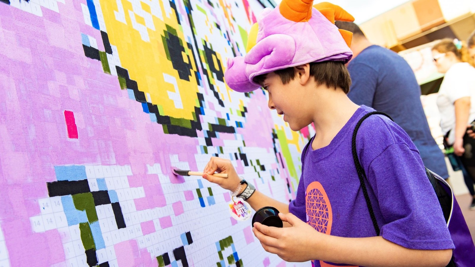 A guest paints a mural during the EPCOT Festival of the Arts