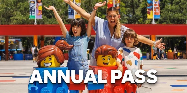 A family poses with two LEGO characters outside LEGOLAND Florida under Annual Pass text.