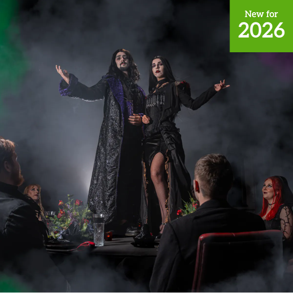 Dine with the Dead performers stand on a banquet table at Alton Towers