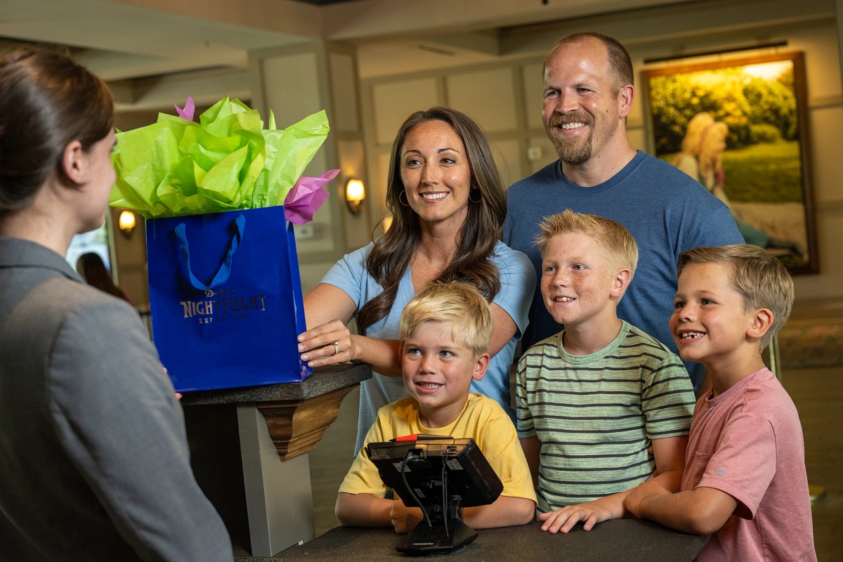 A family receiving a NightFlight Expedition merchandise bundle at a Dollywood resort