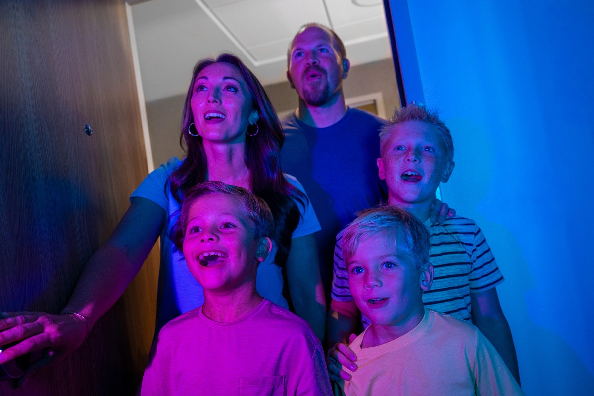A family entering a room illuminated with NightFlight Expedition colors at a Dollywood resort