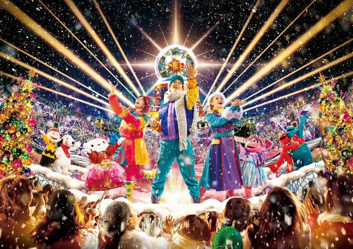 Universal Studios Japan holiday performers and characters on the Gramercy Park stage under lights and falling snow