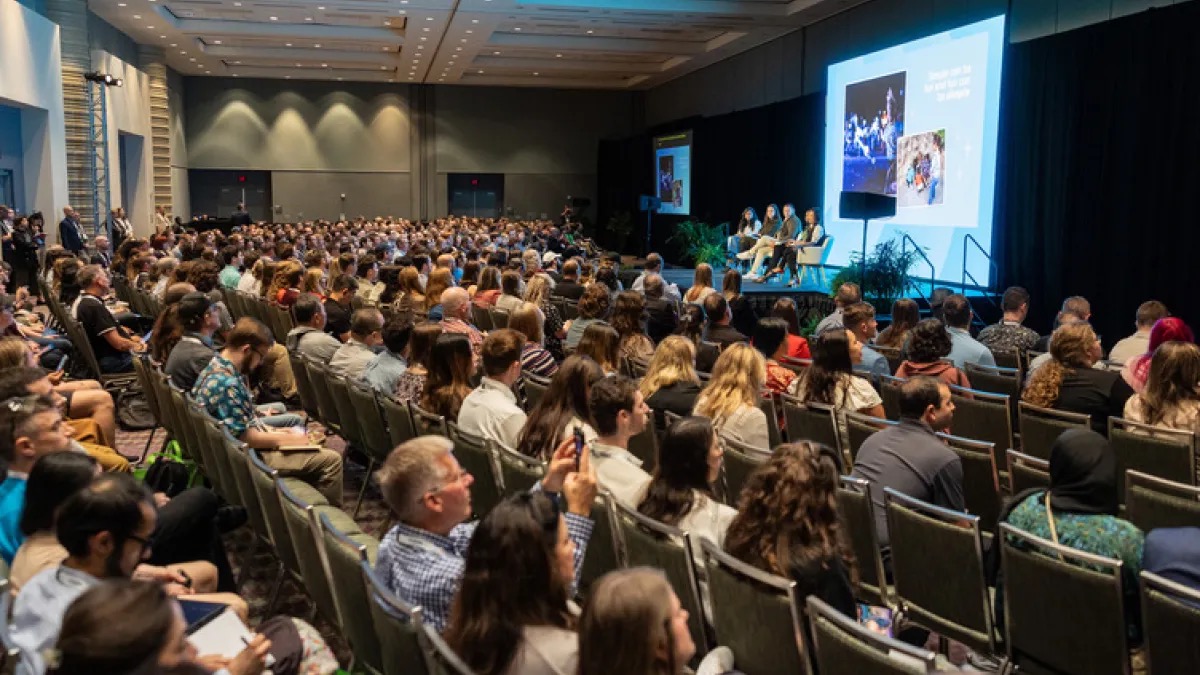 Crowd seated in a packed IAAPA Expo education session facing a panel onstage