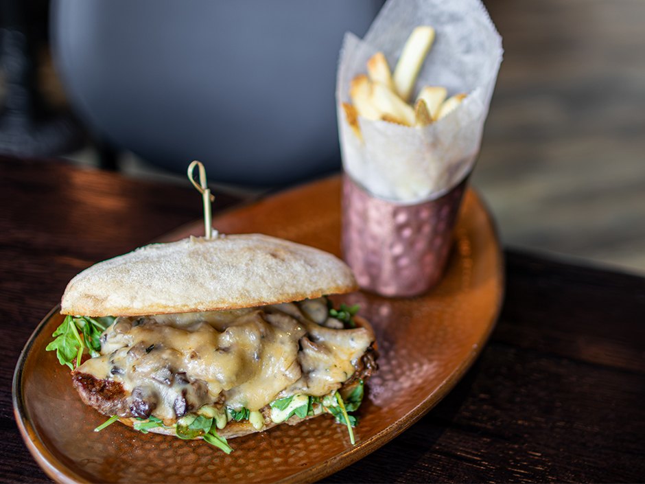 Grilled Steak Sandwich on a French baguette with mushrooms, tomato jam and horseradish cream.