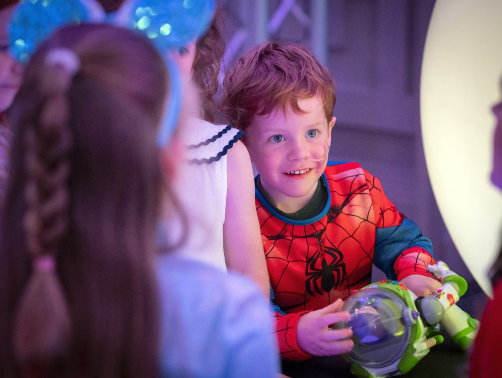 A child holding a Buzz Lightyear toy during the wish-family gathering