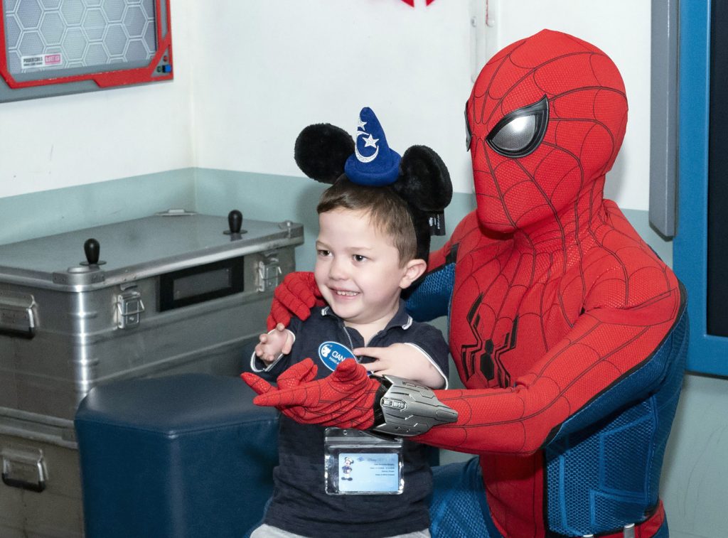 Spider-Man posing with a young guest at the Disney Dream event