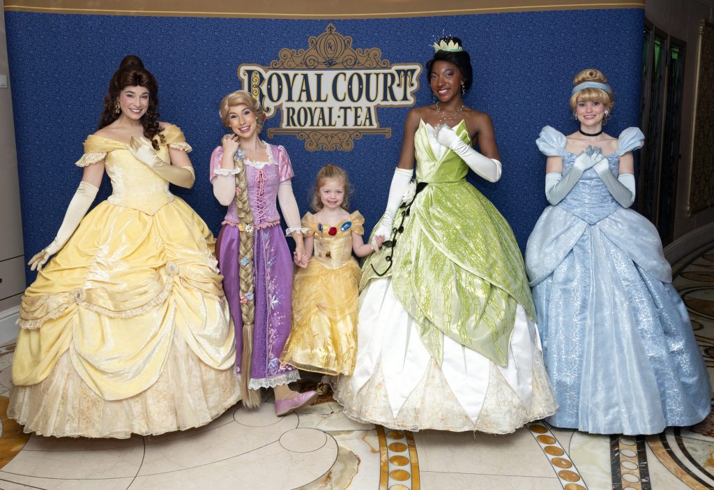 Disney Princesses posing with a young guest at Royal Court Royal Tea