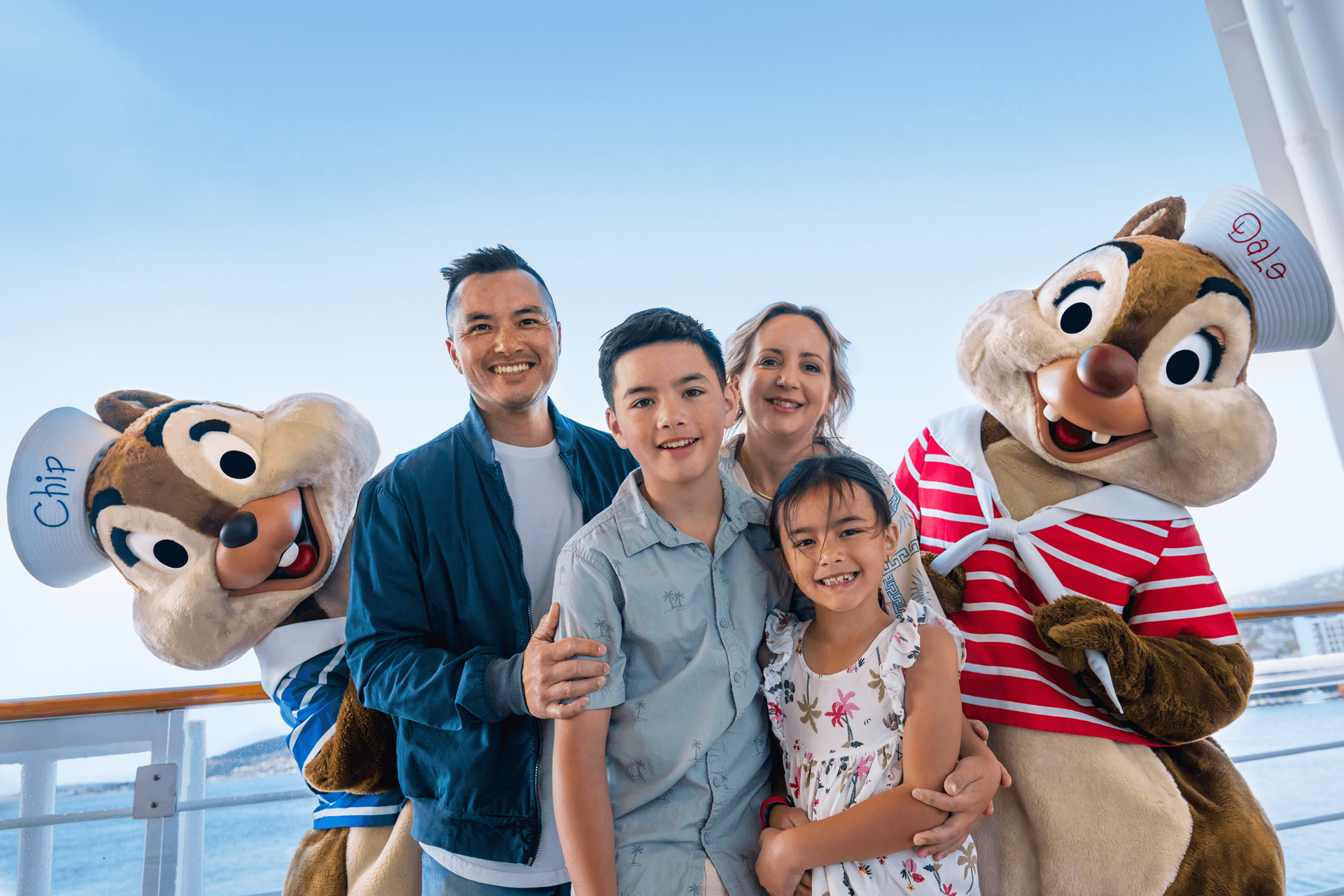 Family posing with Chip and Dale aboard a Disney Cruise Line ship