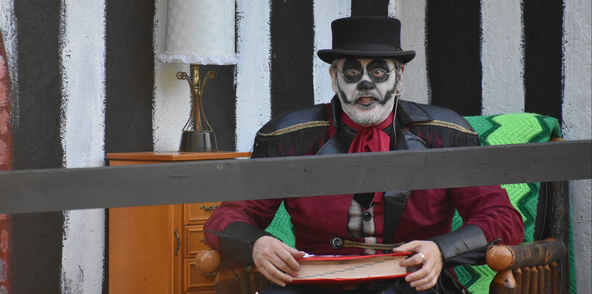 A costumed storyteller holding a book during Weird Tales Story Hour at The Great Escape