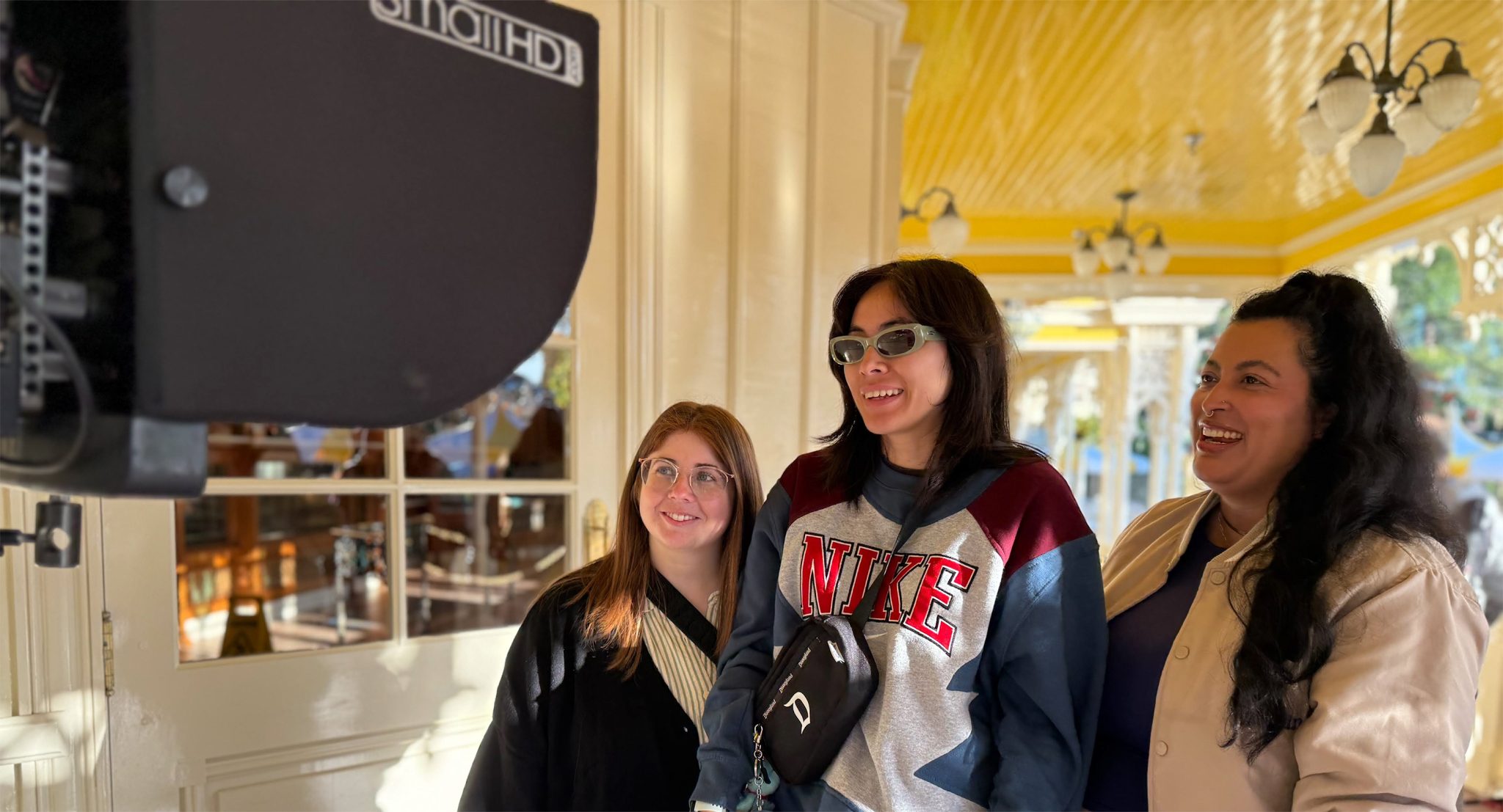 Three Disney Cast Members monitor filming at Walt Disney World