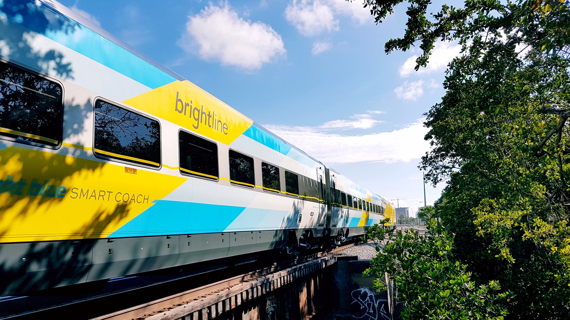 Brightline passenger train crossing a railroad bridge in Florida