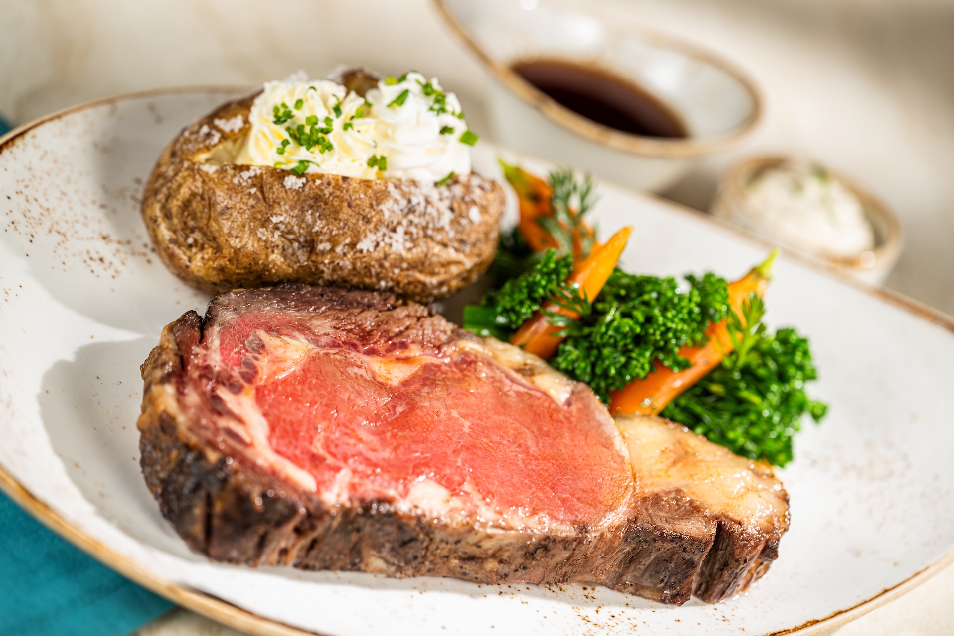 Slow-roasted prime rib with a baked potato and vegetables