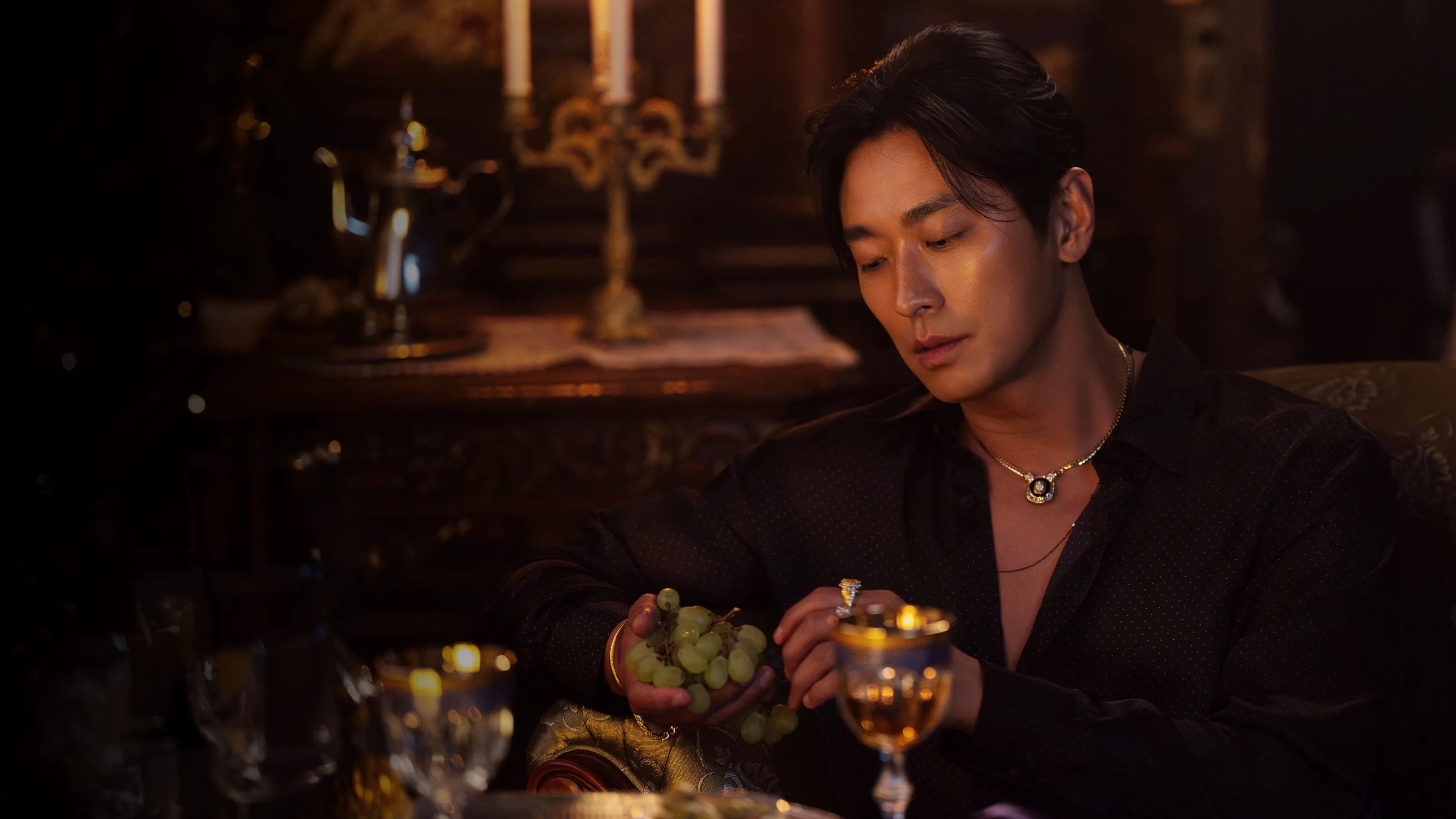 A character from The Remarried Empress seated at a candlelit table