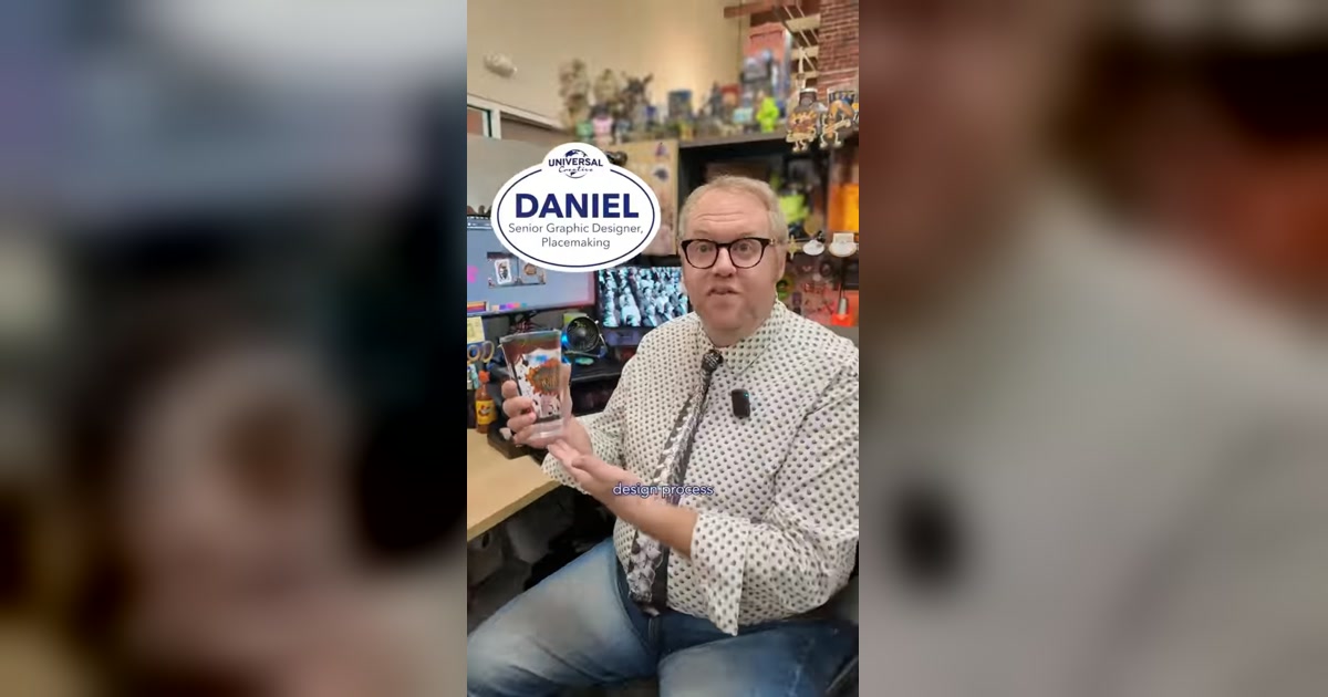Daniel holds a Halloween Horror Nights souvenir cup in Universal Creative’s design studio