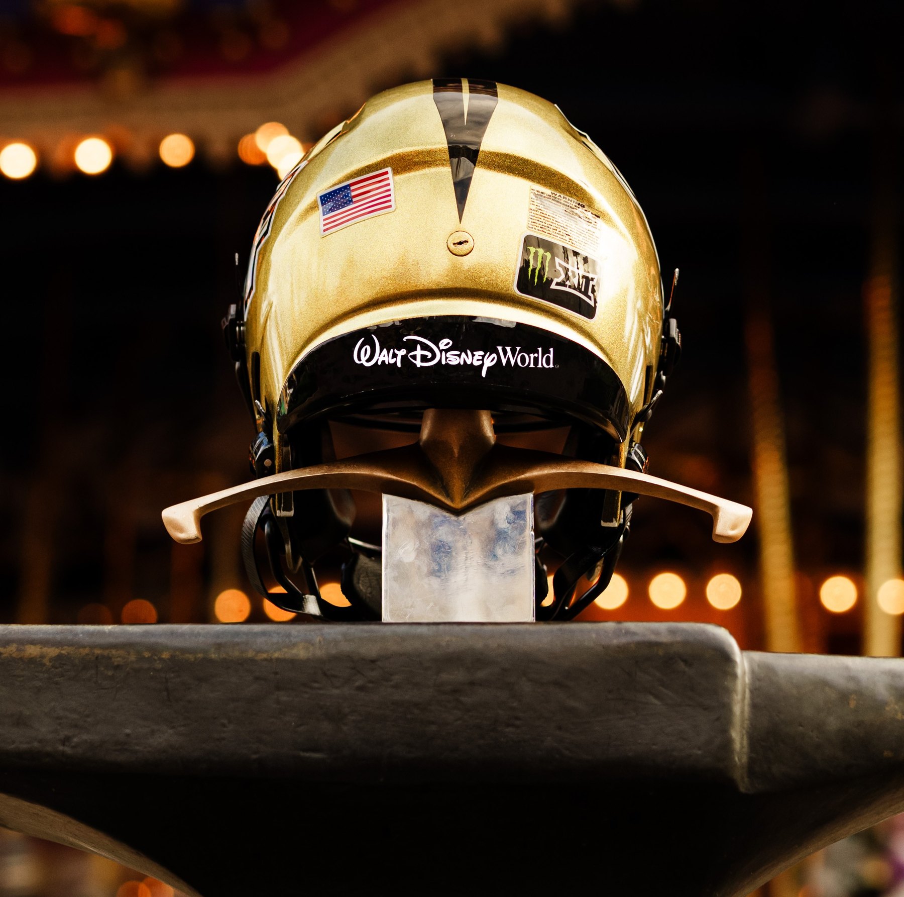 A gold UCF football helmet with the Walt Disney World logo sits on display