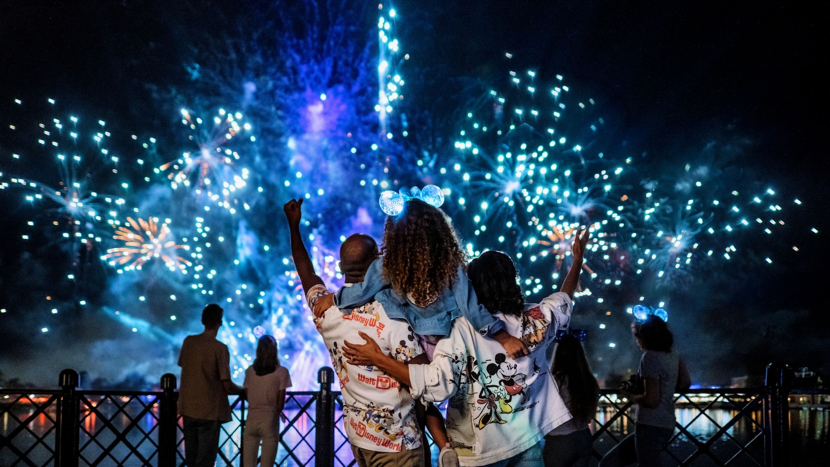A family watches blue fireworks during Luminous: The Symphony of Us at EPCOT