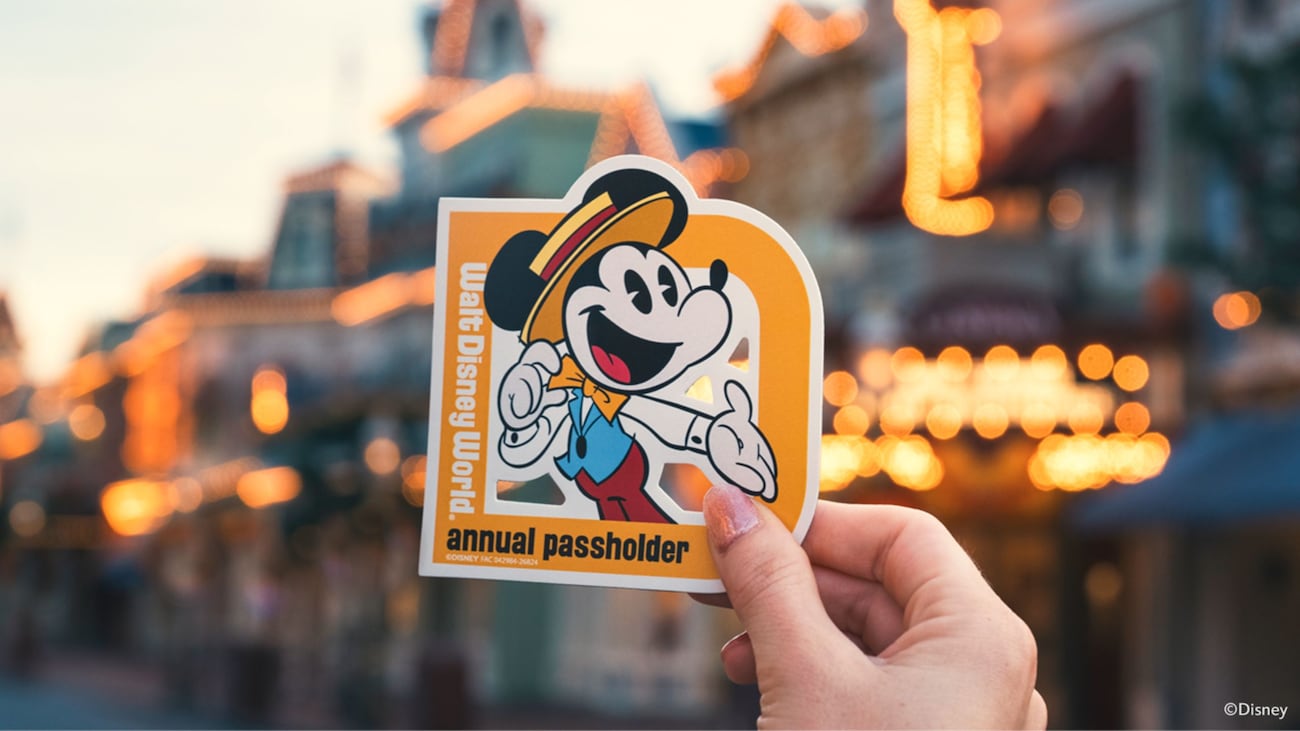 A hand holds the Dapper Mickey Annual Passholder magnet at Walt Disney World