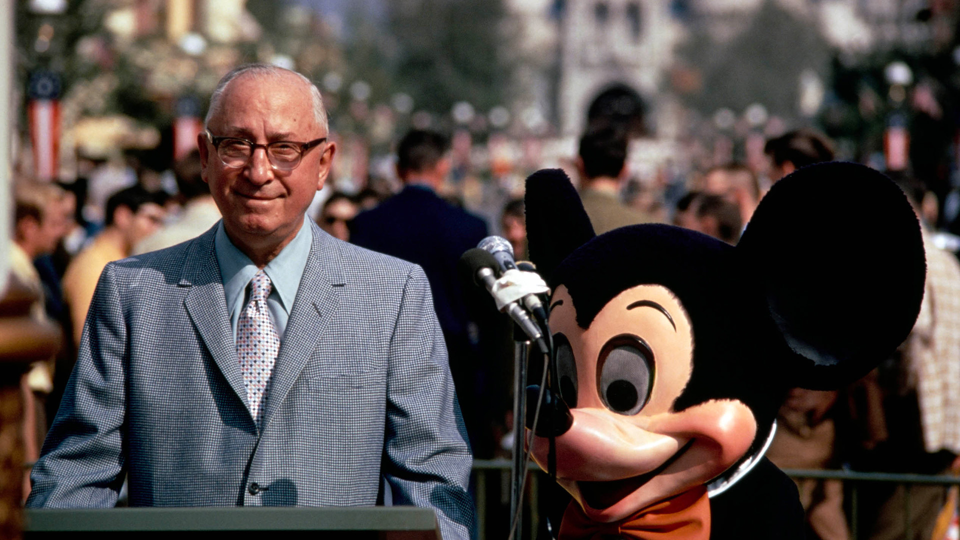 Roy O. Disney stands beside Mickey Mouse during the Walt Disney World dedication ceremony