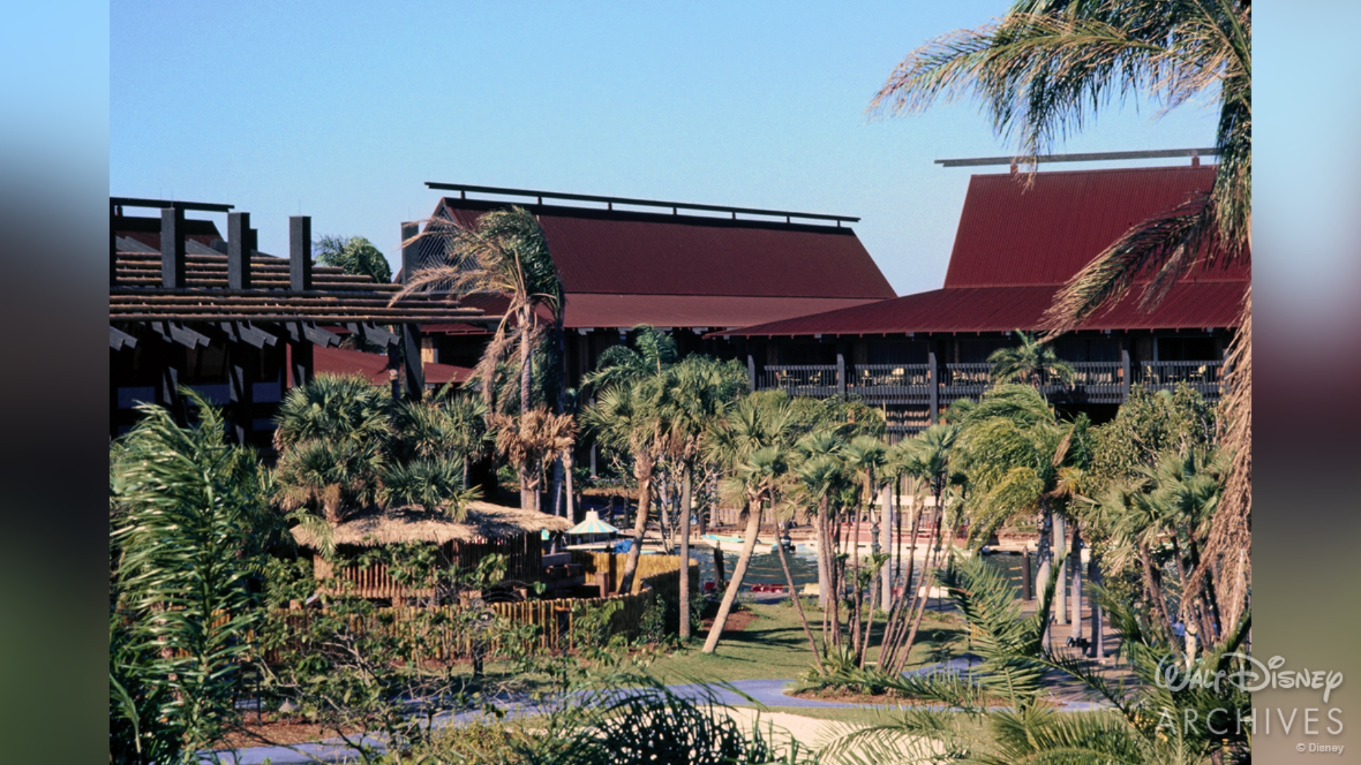The Great Ceremonial House and original longhouses stand behind palm trees in March 1972
