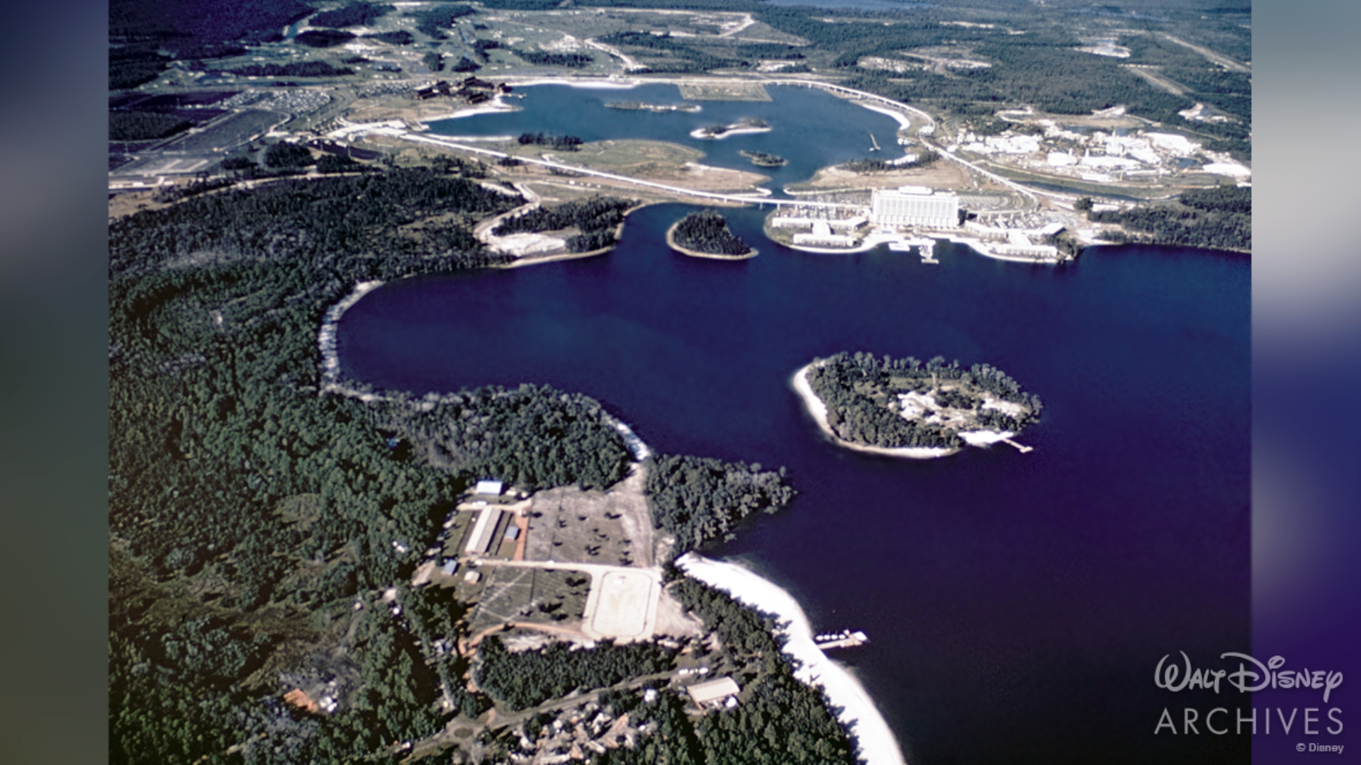 An aerial view shows Fort Wilderness on Bay Lake and Walt Disney World beyond in November 1971