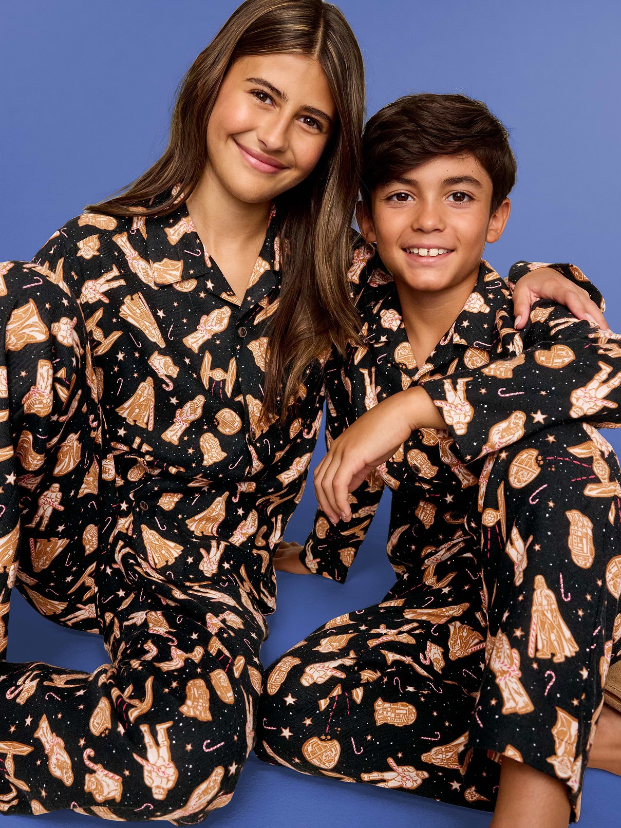 An adult and child wearing black Old Navy Star Wars Cookie pajamas