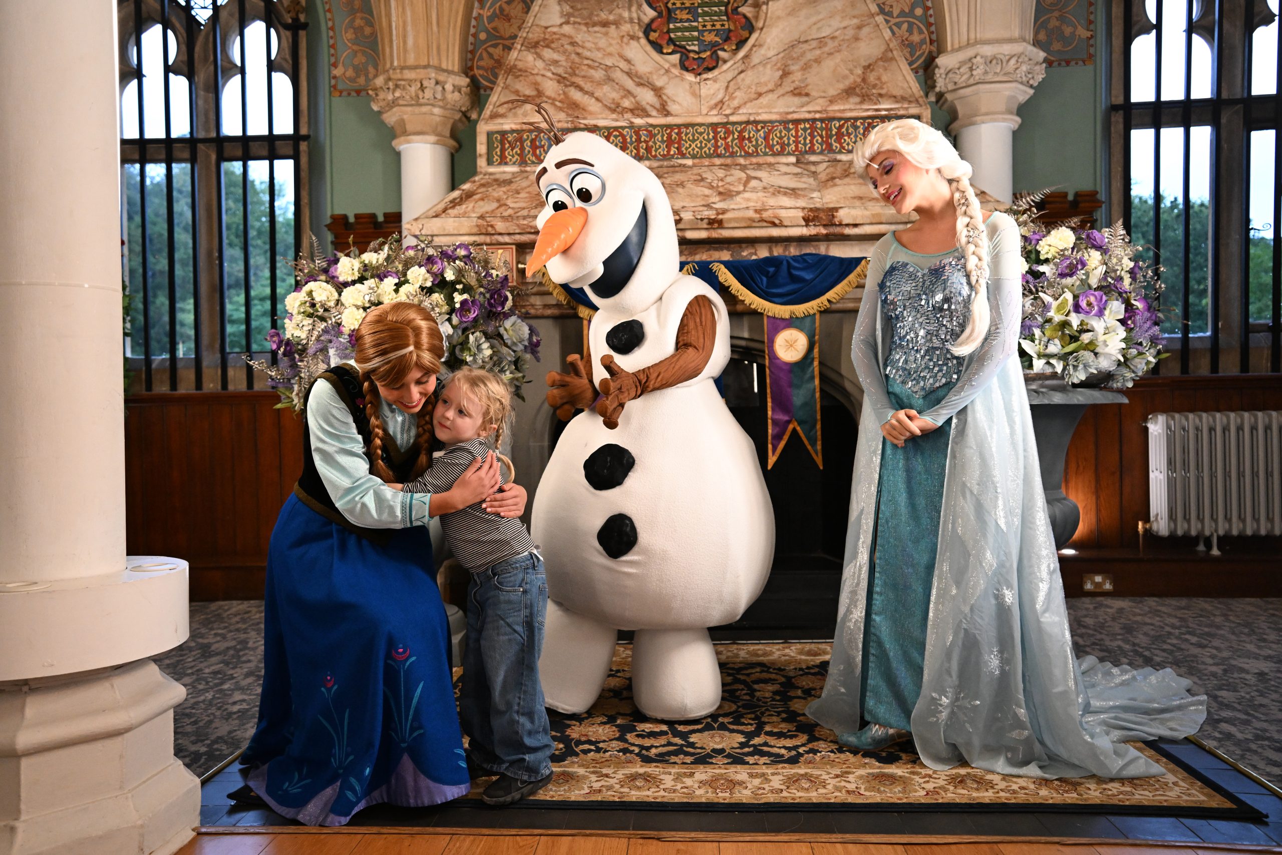 Anna, Olaf and Elsa greet a child at an A Disney Wish event