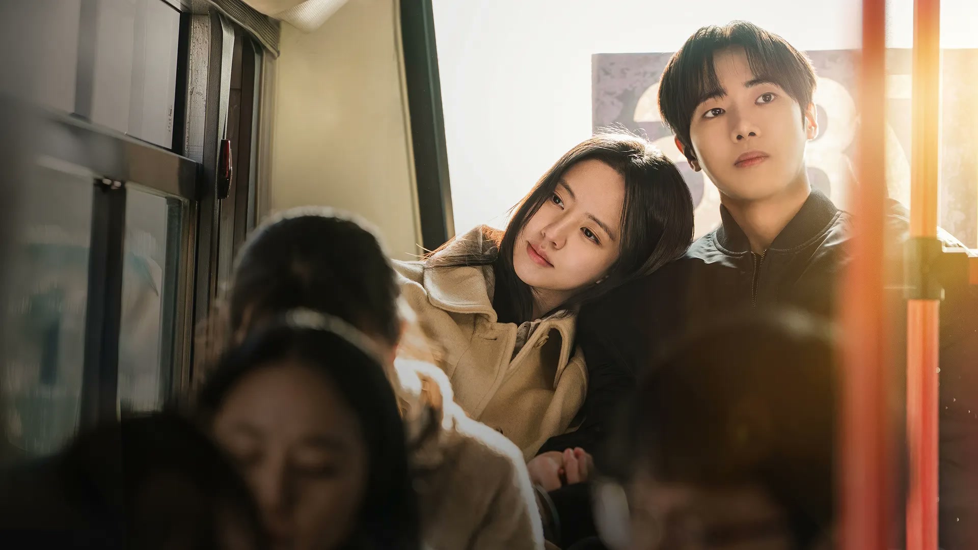 The two leads of Between Steps stand together on public transit