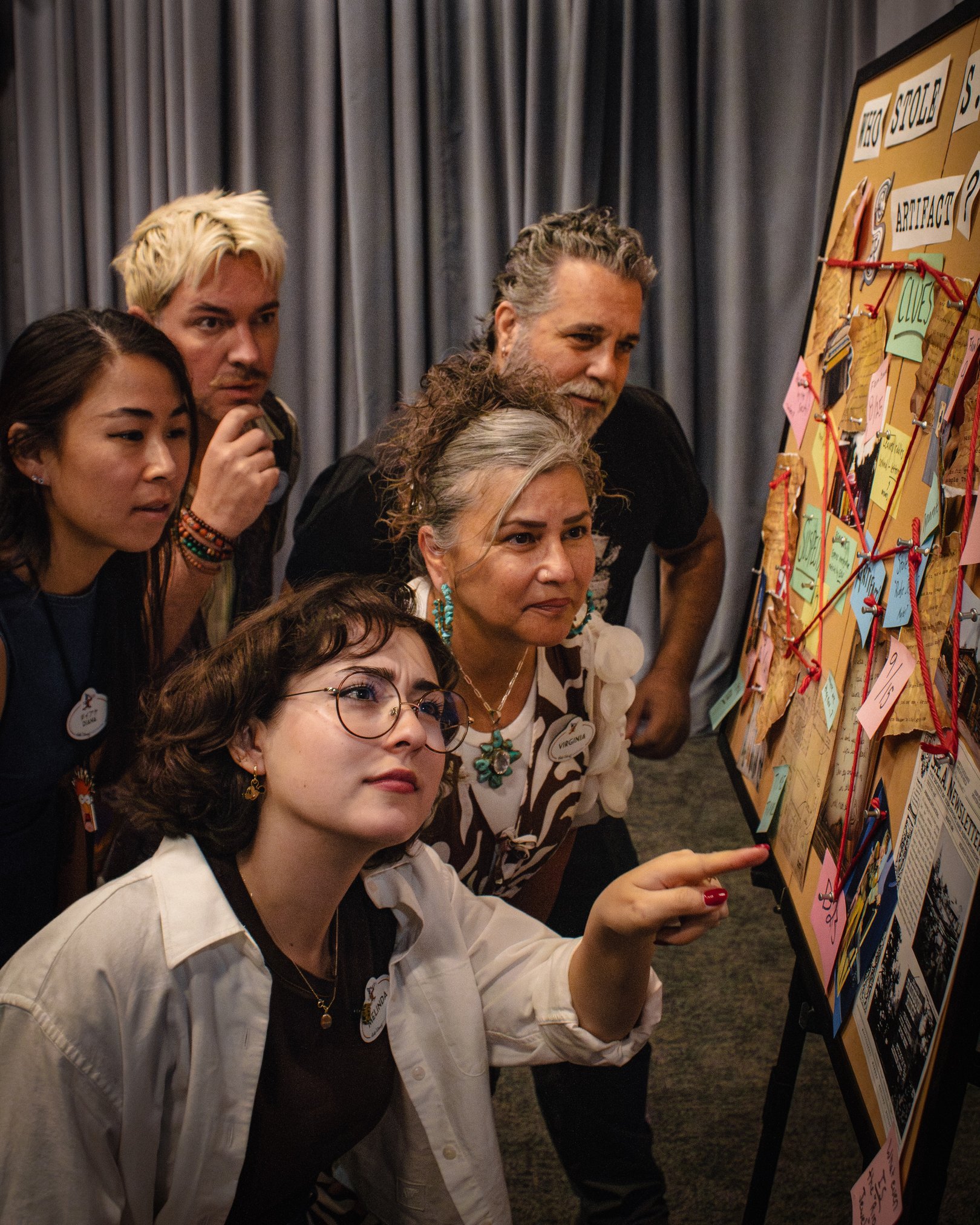 Imagineers and S.E.A. archivist Bonnie Booker study a clue board for Disney’s stolen-artifact mystery