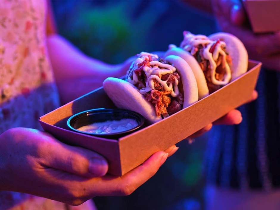 A guest holds three Kimchi Bao served at Epic Universe